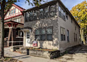 Thumbnail 29 of 29 - A house with a red roof and a grey siding with a white door and windows.