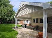 Thumbnail 16 of 19 - a patio with a pergola in front of a brick building