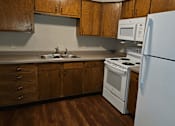 Thumbnail 2 of 19 - a kitchen with white appliances and wooden cabinets