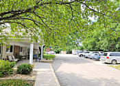 Thumbnail 14 of 19 - a street with a house and cars parked on the side of the road