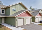 Thumbnail 2 of 38 - A house with a green and red roof and a white garage door.