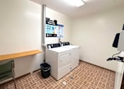 Thumbnail 3 of 6 - A room with a washing machine and a chair.