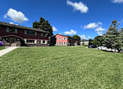 Thumbnail 4 of 4 - A grassy field with a building in the background.