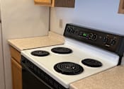 Thumbnail 3 of 4 - A white stove top with four burners and a control panel above it.