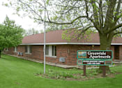 Thumbnail 1 of 4 - A sign for Greenwale Apartments is in front of a brick building.