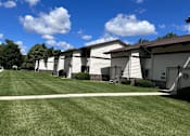Thumbnail 3 of 4 - A row of houses with a blue sky and clouds above.