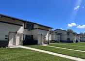 Thumbnail 2 of 4 - A row of houses with a clear blue sky above them.