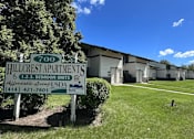 Thumbnail 1 of 4 - A sign for Hillcrest Apartments is displayed in front of a building.