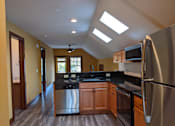 Thumbnail 7 of 29 - A kitchen with a refrigerator, microwave, and oven.