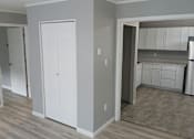 Thumbnail 4 of 8 - A kitchen with white cabinets and a refrigerator.