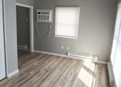 Thumbnail 7 of 8 - A room with wooden flooring and a window with blinds.