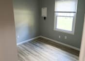 Thumbnail 8 of 8 - A room with a window and a wooden floor.