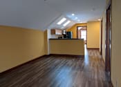 Thumbnail 8 of 29 - A room with wooden floors and a yellow wall.