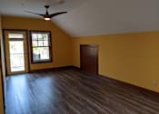 Thumbnail 9 of 29 - A room with a ceiling fan and sliding glass doors.