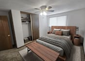 Thumbnail 4 of 5 - A bedroom with a bed, a bench, and a ceiling fan.