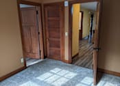 Thumbnail 13 of 29 - A room with a tan wall and a wooden floor with a carpet.