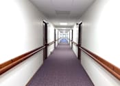Thumbnail 3 of 14 - A long hallway with purple carpeting and white walls.