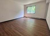 Thumbnail 6 of 14 - A room with wooden flooring and a window.