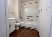 Thumbnail 11 of 14 - A white bathroom with a toilet, sink, and bathtub.