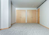 Thumbnail 10 of 31 - A room with two doors and carpeted floor.