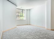 Thumbnail 9 of 31 - A room with a carpeted floor and a window.