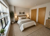 Thumbnail 9 of 37 - A bedroom with a large bed, two nightstands, and a window with blinds.
