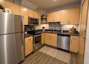 Thumbnail 5 of 37 - A modern kitchen with wooden cabinets and stainless steel appliances.
