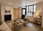 Thumbnail 4 of 37 - A living room with a fireplace and a painting on the wall.