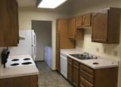 Thumbnail 2 of 16 - A kitchen with a white stove top oven and white refrigerator.