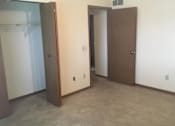 Thumbnail 10 of 16 - A room with a brown door and a white wall.