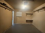 Thumbnail 16 of 16 - A room with a door, a shelf, and a light fixture.