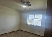 Thumbnail 5 of 16 - A room with a ceiling fan and a window.