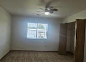 Thumbnail 6 of 16 - A room with a ceiling fan and a window with blinds.