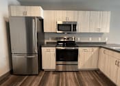 Thumbnail 10 of 29 - a kitchen with a stainless steel refrigerator freezer and a stove top oven