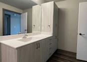 Thumbnail 21 of 29 - a bathroom with white cabinets and a white sink