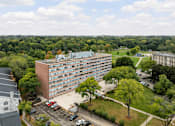 Thumbnail 14 of 16 - A large building with a parking lot in front of it.