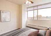 Thumbnail 10 of 16 - A bedroom with a large bed and a ceiling fan.