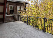 Thumbnail 15 of 29 - A patio with a black railing and a grey concrete floor.