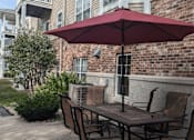 Thumbnail 31 of 37 - a table with chairs and an umbrella on a patio