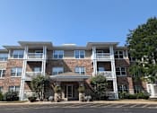 Thumbnail 2 of 37 - a large brick apartment building with trees in front of it