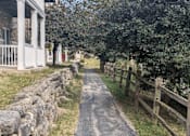Thumbnail 34 of 37 - a dirt path next to a wooden fence and a house