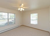 Thumbnail 9 of 37 - a bedroom with a ceiling fan and two windows
