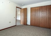 Thumbnail 12 of 37 - an empty room with two doors and a door to a hallway