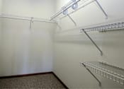 Thumbnail 15 of 37 - a walk in closet with white walls and two shelves on the wall
