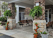 Thumbnail 4 of 37 - a porch with benches and potted plants in front of a building
