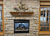 Thumbnail 19 of 37 - a large stone fireplace in a living room with a shelf above it