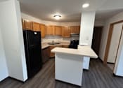 Thumbnail 8 of 21 - A kitchen with black appliances and wooden cabinets.