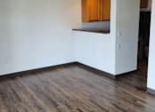 Thumbnail 13 of 21 - A room with wooden floors and white walls.