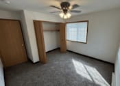 Thumbnail 14 of 21 - A room with a ceiling fan and a window with blinds.