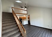 Thumbnail 5 of 21 - A room with a staircase and a ceiling fan.